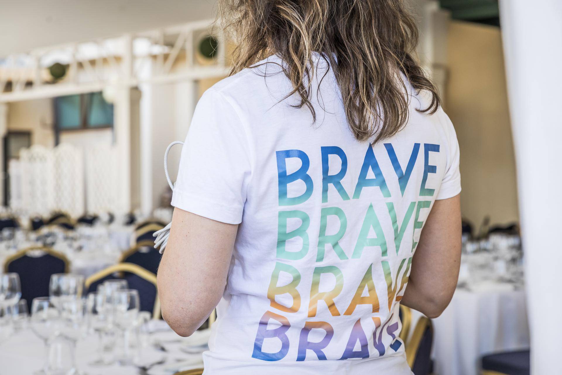 En fullsatt middagssal med lyssatt scene i lilla og gull